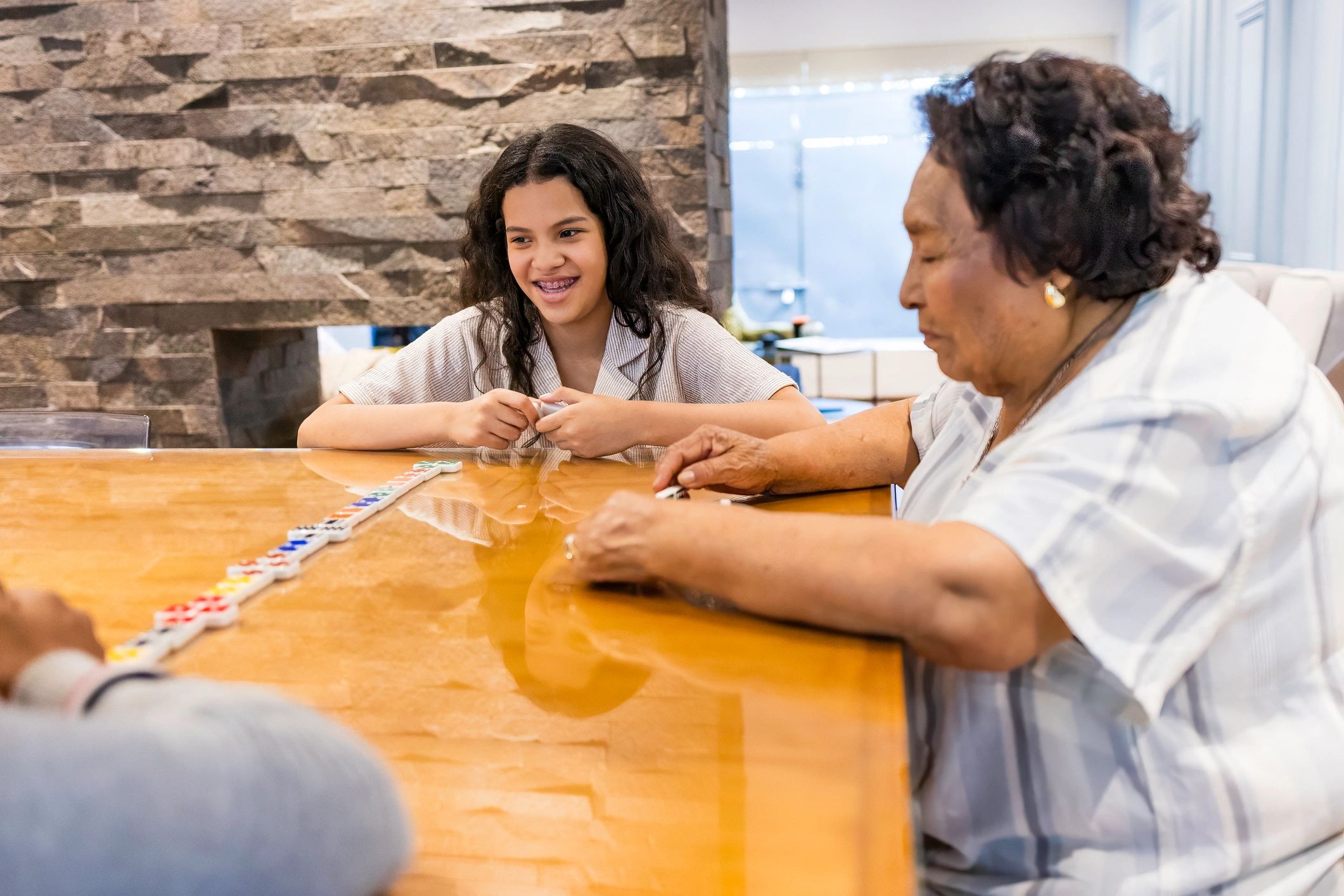 Teenage siblings playing domino with their grandmother at home